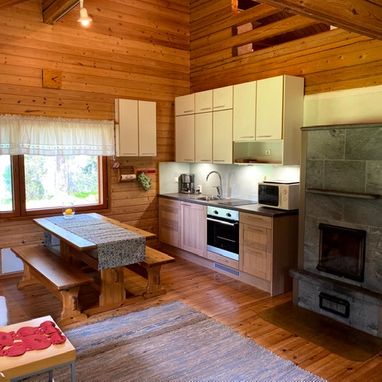 Niemikotkan Ilves -mökin olohuone-keittiö on tilava ja viihtyisä. Tulikiviuuni lämmittää ja tuo tunnelmaa erityisesti keväällä ja syksyllä
