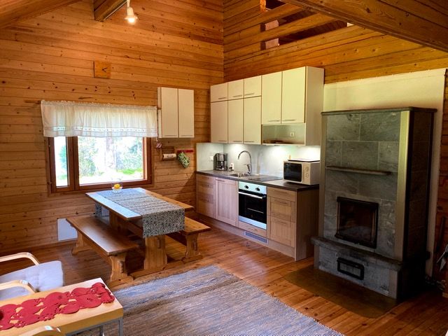 Niemikotkan Ilves -mökin olohuone-keittiö on tilava ja viihtyisä. Tulikiviuuni lämmittää ja tuo tunnelmaa erityisesti keväällä ja syksyllä